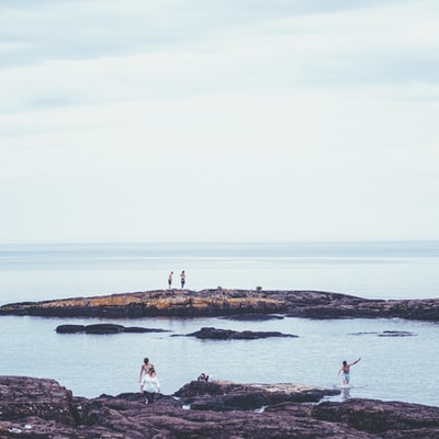 During the day, the people standing in the rocks of the seaside
